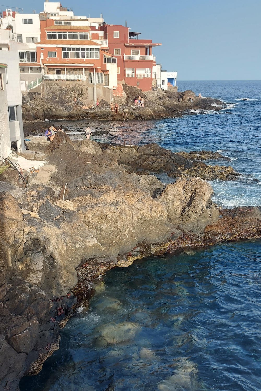 Casas junto al mar en Boca Cangrejo, Tenerife, con roca volcánica y cielo despejado